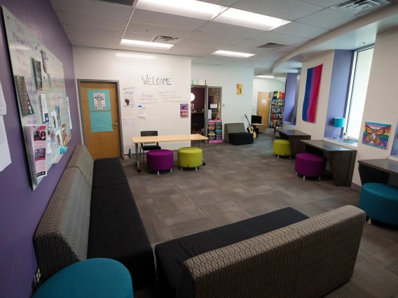 Common area filled with couches and colorful stools