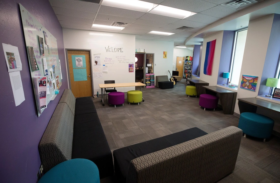 Common area filled with couches and colorful stools