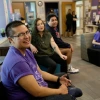 Members of LGBTQ sitting in common area smiling for a photo