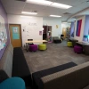 Common area filled with couches and colorful stools